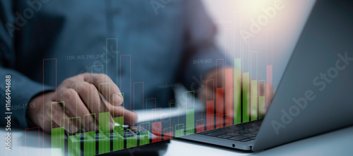 Businessman operating a calculator and laptop with digital bar charts and financial data overlays. business analytics, financial management and data-driven decision-making for modern enterprises photo