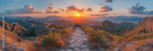A stunning sunset view over mountainous terrain with a stone pathway.