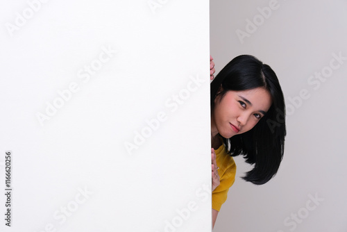 Tableau sur toile A woman peeking out behind a wall with suspicious expression
