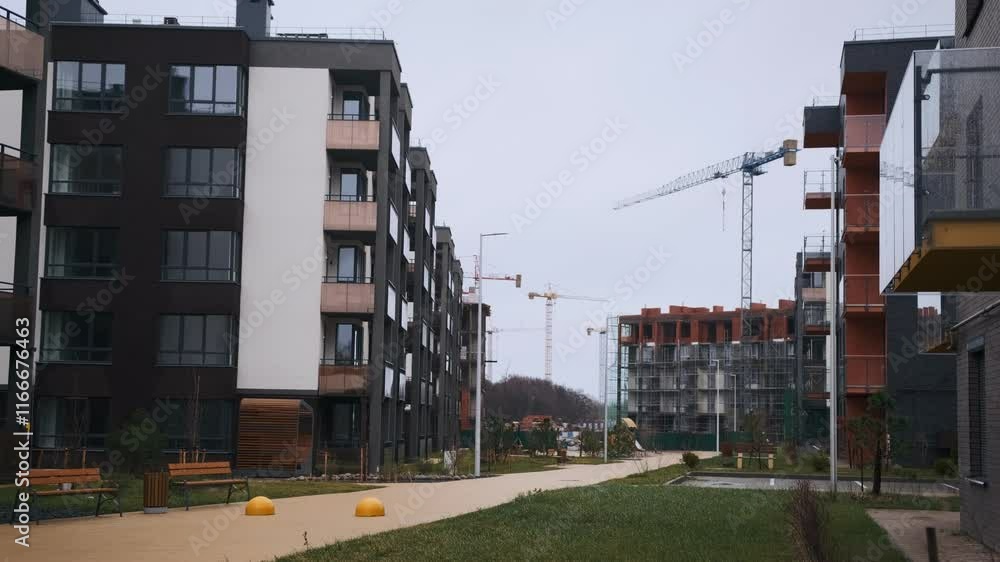 Modern Residential Buildings Under Construction in an Urban Area With Cranes in the Background Modern Residential Buildings Under Construction in an Urban Area With Cranes in the Background