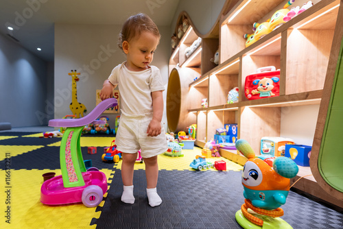 Young child having fun in a colorful playroom with educational toys and engaging activities. Concept of joyful play and early education photo