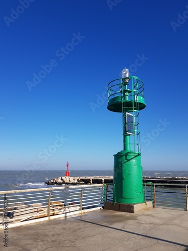 Lighthouse on the pier in a sunny day with a blue sky