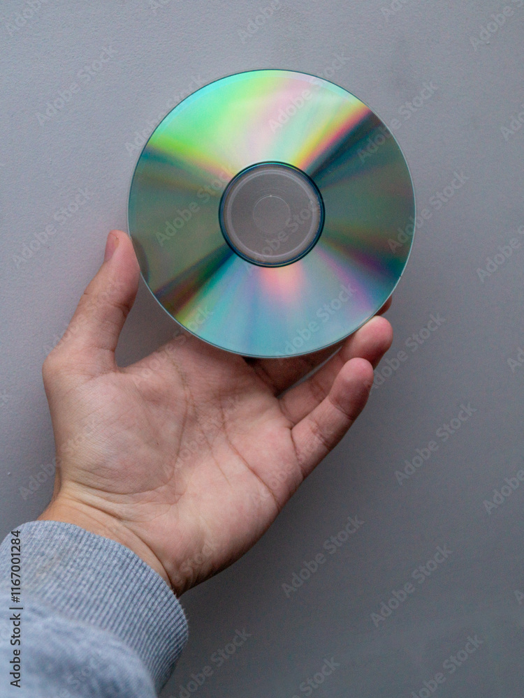 CD disk in hand, compact disk, retro technology, digital medium, iridescent disk, old media, hand holding disk, DVD, minimalistic background CD disk in hand, compact disk, retro technology, digital medium, iridescent disk, old media, hand holding disk, DVD, minimalistic background