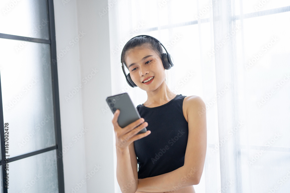 Fitness asian woman using smart phone and headphones Enjoy listening to music. Female with headphones smart phone after workout Fitness asian woman using smart phone and headphones Enjoy listening to music. Female with headphones smart phone after workout