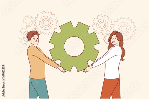 Teamwork of industrial employees together holding gear from production mechanism. Teamwork of man and woman demonstrating trusting partnership and ability to work in team, achieving synergy