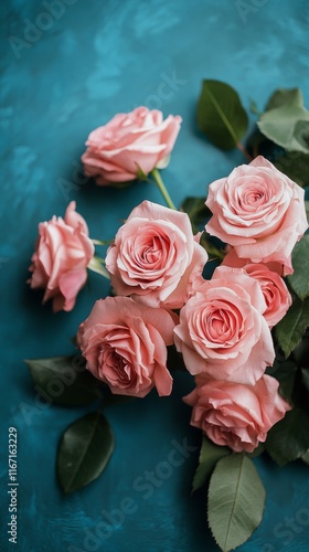 Beautiful bouquet of pink roses arranged against a bright blue background
