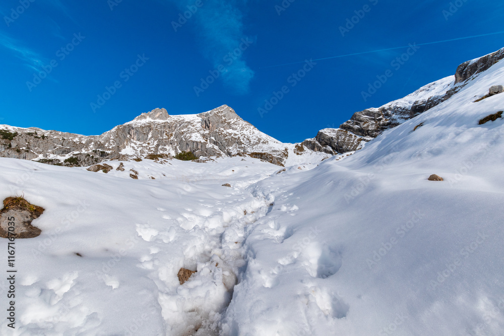 Obraz premium Winter Landscape in the Rofan Alps with Footprints in Deep Snow and Rocky Peaks