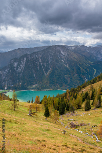 Autumn Forest in the Rofan Mountains, Tyrol, Austria, with Golden Larch Trees and Rocky Peaks with lake achensee