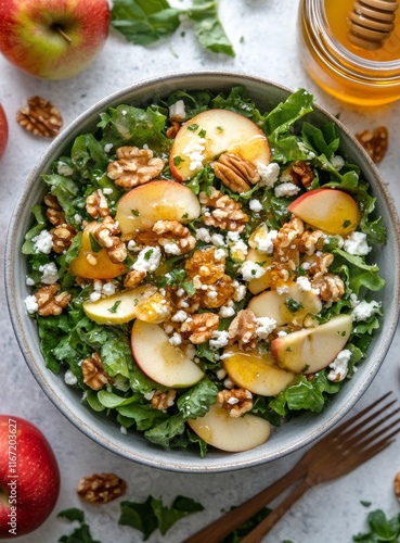 Fresh apple walnut salad with goat cheese and honey dressing on a marble coun...