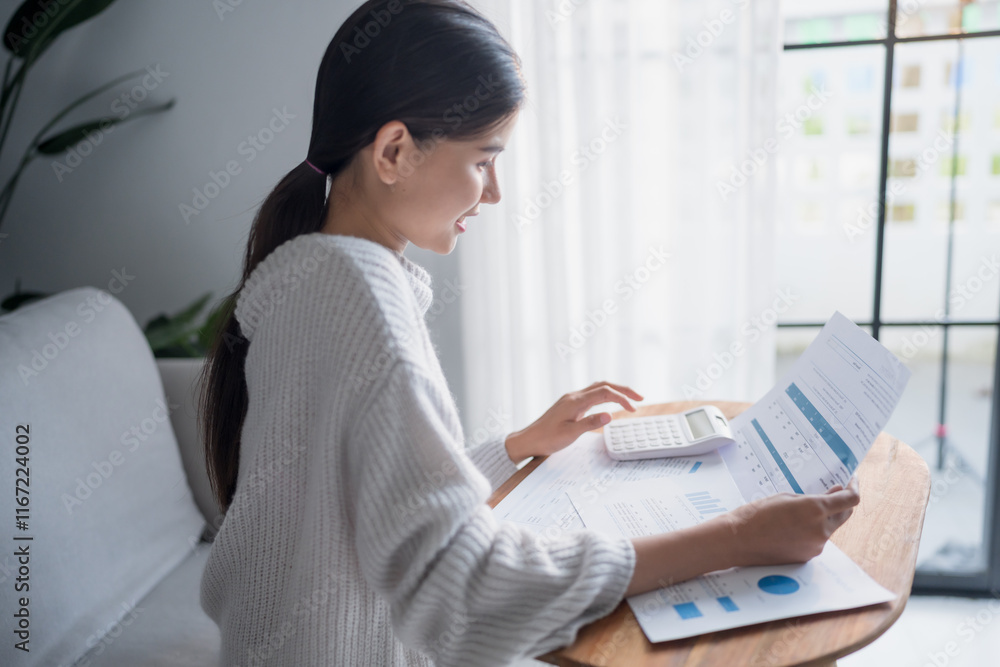 Businesswoman Accountant analyzing investment charts Invoice and pressing calculator buttons over documents. Accounting at home Businesswoman Accountant analyzing investment charts Invoice and pressing calculator buttons over documents. Accounting at home