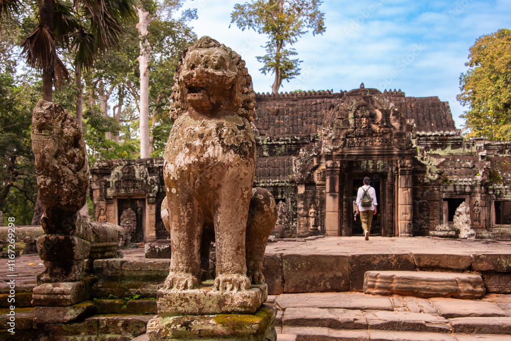 Fototapeta premium Tourist entering Angkor ancient temple ruins in Cambodia