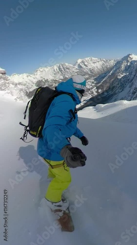 SELFIE: Snowboard tourist sprays fresh snow while riding down the snowy mountain on an adventure trip in beautiful Albanian Alps. He enjoys riding steep untouched terrains among snowed mountaintops. photo