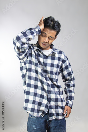 a man in a plaid shirt holding his head having a headache or pain health isolated on white background