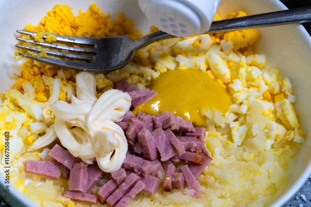 adding salt to the ingredient of egg sandwich in the bowl
