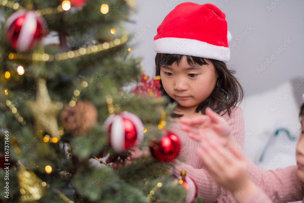 女の子たちが一緒に楽しむクリスマスツリーのデコレーション 女の子たちが一緒に楽しむクリスマスツリーのデコレーション