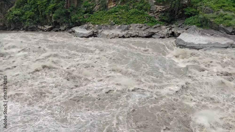 Raging river flows through steep mountains in wild natural landscape Raging river flows through steep mountains in wild natural landscape