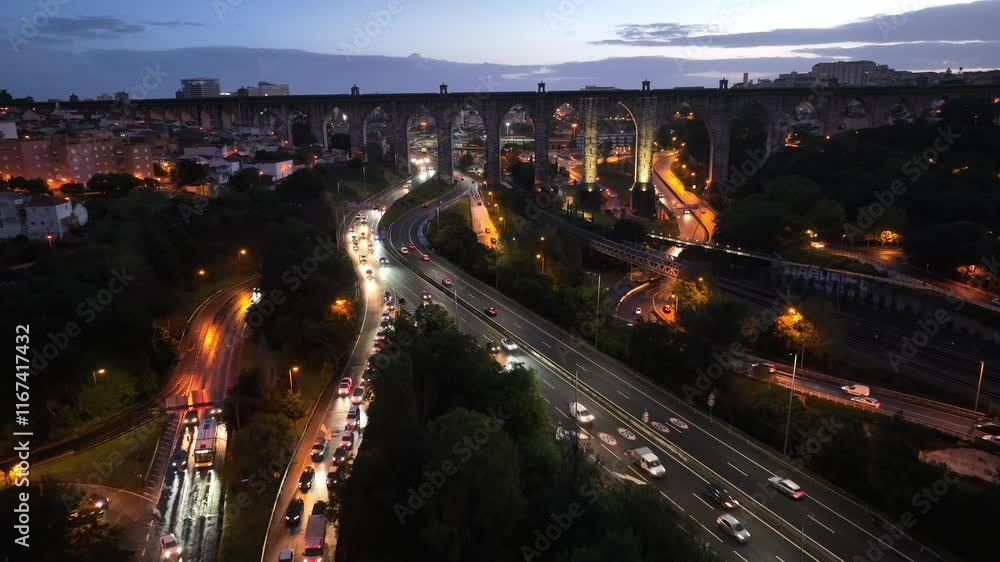 Aerial video of highway with multiple lanes passing under historic aquaduct in Lisbon, Portugal