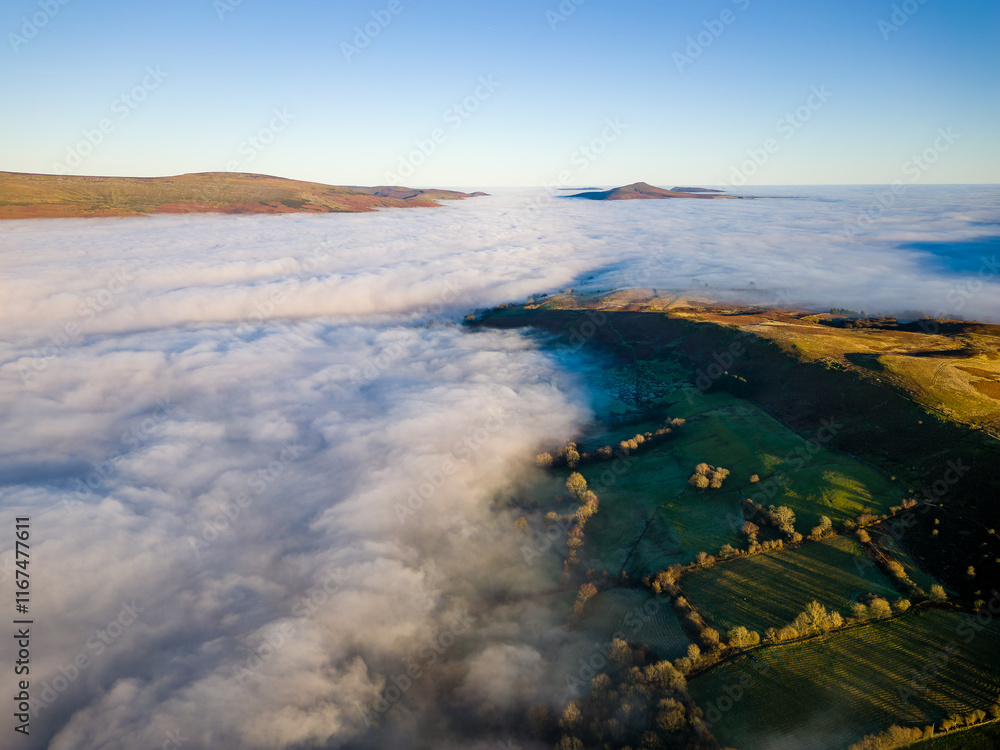 Fototapeta premium Aerial shot of fog blanketing rural farmland in Wales