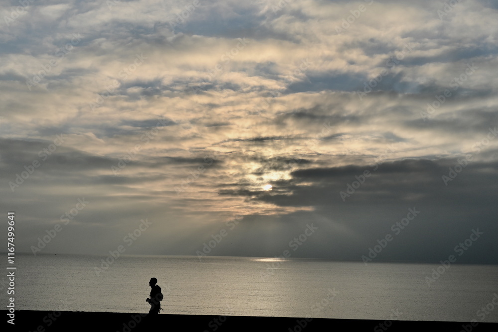 Fototapeta premium jogger silhouette running along the coast near sunset