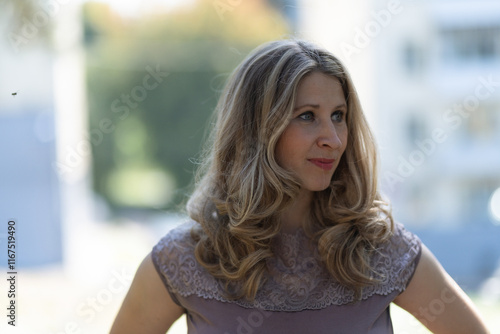 Portrait of a beautiful blonde young girl in a summer city park. Free Download Portrait of a beautiful blonde young girl in a summer city park. - GFXLoad