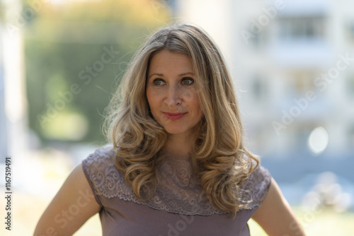 Portrait of a beautiful blonde young girl in a summer city park. Free Download Portrait of a beautiful blonde young girl in a summer city park. - GFXLoad