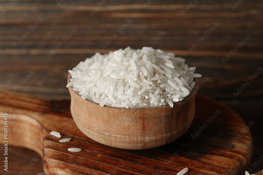 Bowl with raw rice on wooden background, closeup Bowl with raw rice on wooden background, closeup