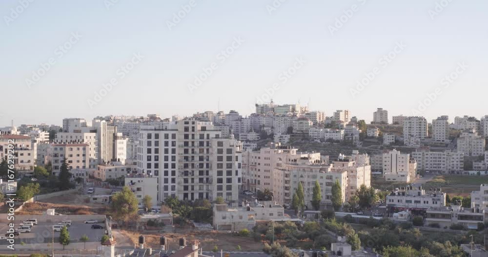 Dark Ramallah Cityscape at Dawn with High White Buildings and Trees Against Cloudy Sky Dark Ramallah Cityscape at Dawn with High White Buildings and Trees Against Cloudy Sky