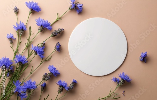 Floral arrangement with blue flowers and a round plate on a soft background
