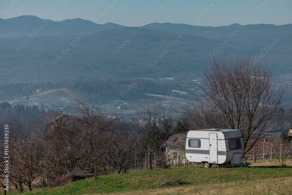 Old vintage caravan trailer used as an alternative for a cottage or holiday home. Early winter setting, great view from the place where caravan is..