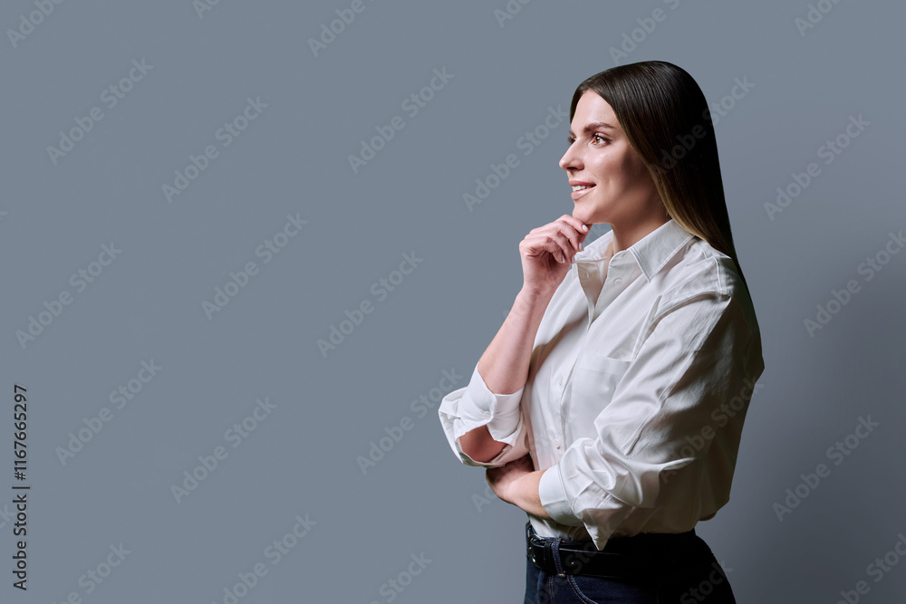 Profile view of young thinking woman on gray studio background, copy space Profile view of young thinking woman on gray studio background, copy space