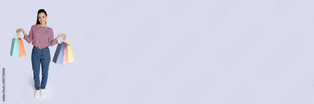Cute young lady showing her purchases over grey studio background, enjoying shopping during season sale, panorama with copy space Cute young lady showing her purchases over grey studio background, enjoying shopping during season sale, panorama with copy space