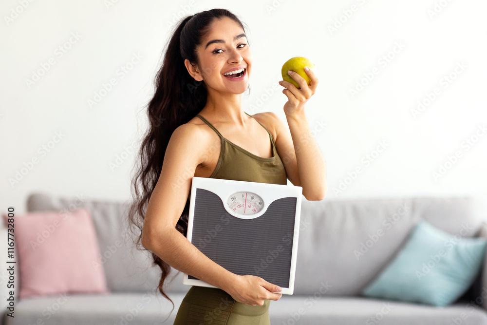 Portrait of millennial Indian lady holding scales and eating apple, choosing healthy diet, panorama. Young Hindu woman preferring wholesome nutrition. Wellbeing and weight loss concept Portrait of millennial Indian lady holding scales and eating apple, choosing healthy diet, panorama. Young Hindu woman preferring wholesome nutrition. Wellbeing and weight loss concept