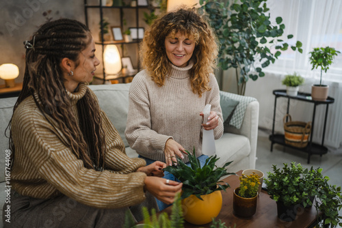 two female friends plant flowers together take care of home plants