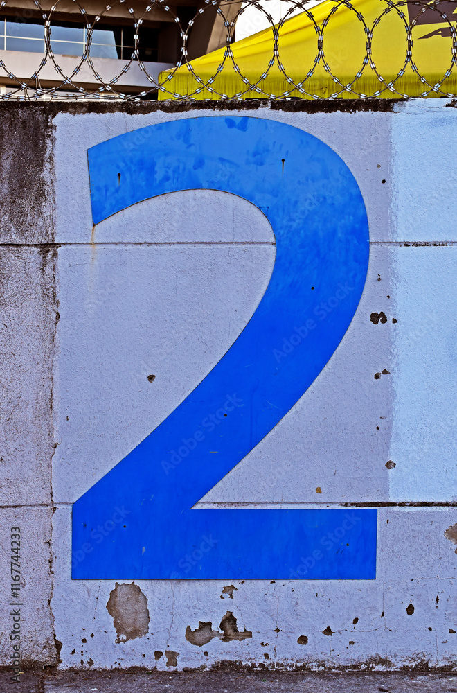 Number two in blue on white wall