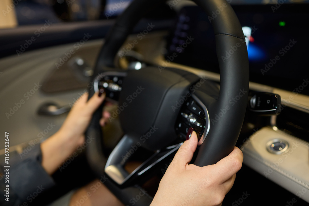 Fototapeta premium An up close image of a hand precisely adjusting a control in a luxurious automobile interior