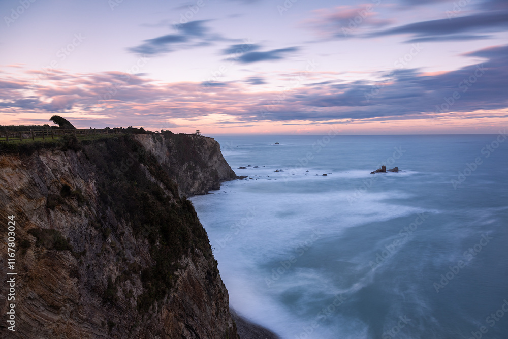 Coastline. The coastline takes us towards the colours that the sunrise is leaving in the clouds Coastline. The coastline takes us towards the colours that the sunrise is leaving in the clouds