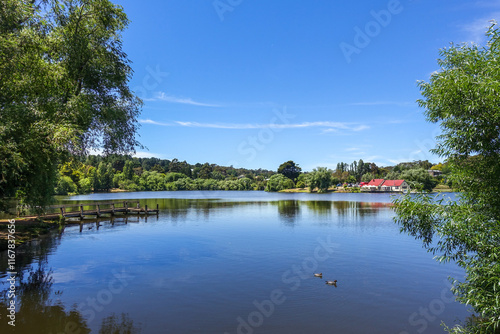 Beautiful scenery at Lake Daylesford in Victoria, Australia, featuring a wooden jetty extended into calm waters and traditional buildings in the distance. A charming small regional town in Australia. photo