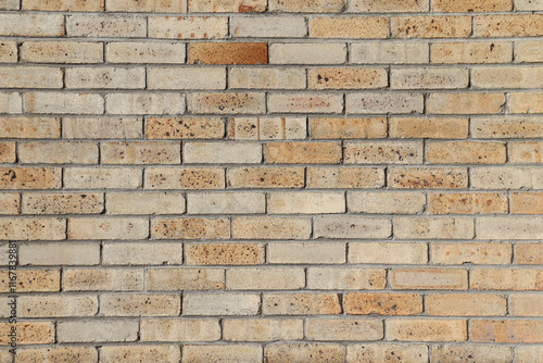 A close-up of an wall of a building with bricks. Construction material with yellow and brown bricks. Background or backdrop with brown and beige colors.