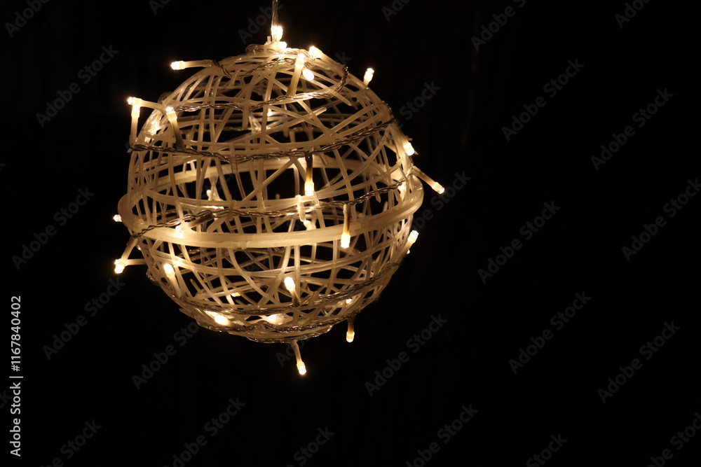 Obraz premium A big ball with lights and a black background. Festivities and outdoor lights. Holidays decorations and spere with little lights.