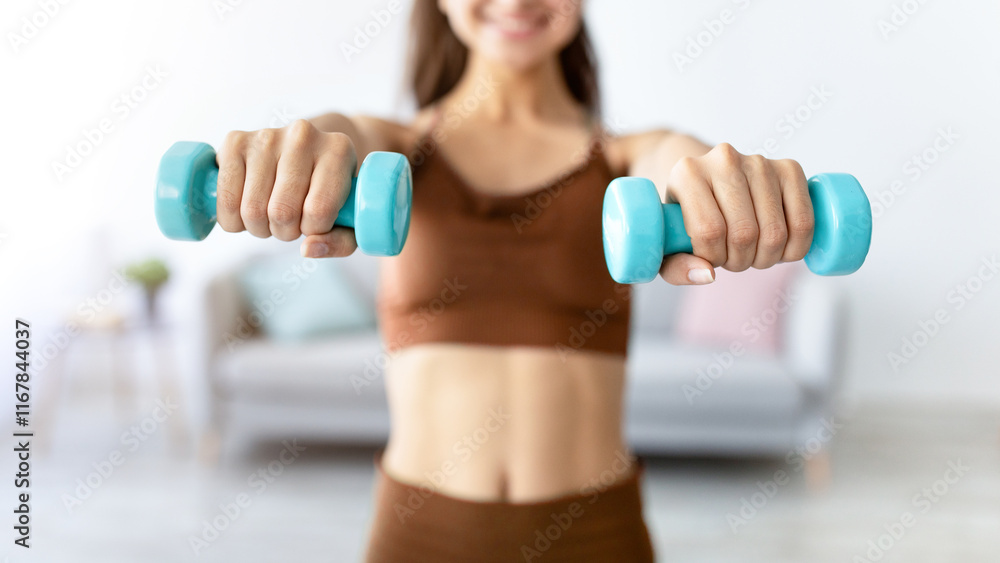 Cropped view of young Indian lady exercising with dumbbells at home during coronavirus epidemic, selective focus. Unrecognizable Eastern woman pumping her arm muscles, having strength training indoors Cropped view of young Indian lady exercising with dumbbells at home during coronavirus epidemic, selective focus. Unrecognizable Eastern woman pumping her arm muscles, having strength training indoors