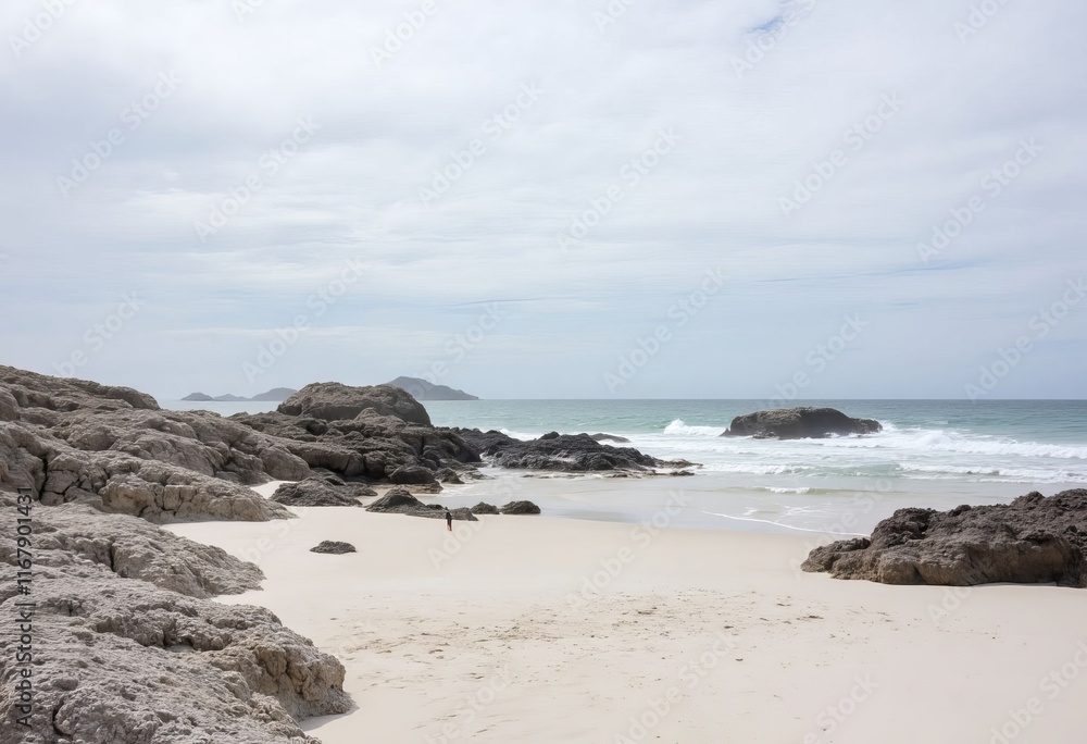 Person on sandy beach with dark rocks and ocean waves Person on sandy beach with dark rocks and ocean waves
