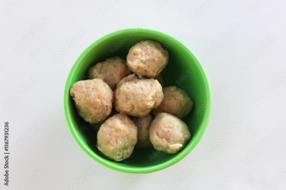 Close up of small meatballs in a green bowl, isolated on white background Close up of small meatballs in a green bowl, isolated on white background