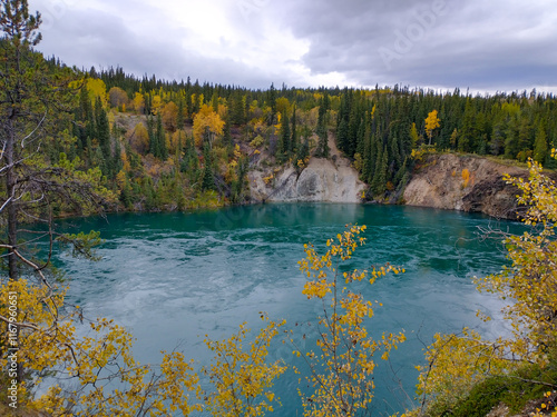 A chilly lake near Whitehorse Yukon with colorful trees as autumn shifts into winter  photo