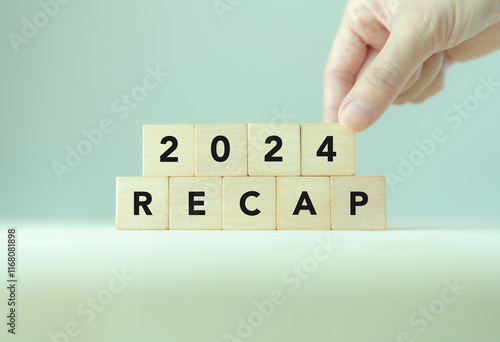 2024 Recap economy, business, financial concept. Business planning in 2025. RECAP text on wooden blocks and hand  placing of 2024  on wooden blocks on minimal grey background and copy space. photo