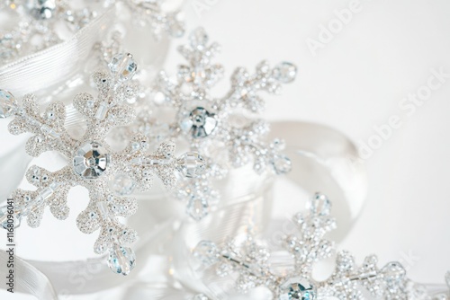 Silver glitter snowflakes with crystals, adorned with a white ribbon, create a festive winter scene.