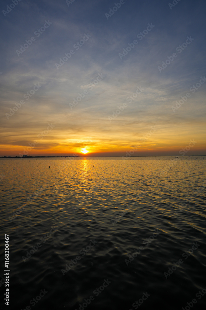 Naklejka premium Natural Sunset Sunrise Over Sea, Bright Dramatic Sky And Dark Ground. Countryside Landscape Under Scenic Colorful Sky At Sunset Dawn Sunrise. Sun Over Skyline, Horizon. Warm Color.