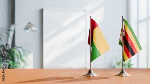 FLAGS OF GUINEA-BISSAU And ZIMBABWE ON TABLE photo