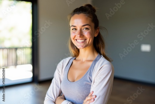 Smiling young woman in casual attire posing indoors, perfect for lifestyle, fitness, or marketing campaigns. Free Download Smiling young woman in casual attire posing indoors, perfect for lifestyle, fitness, or marketing campaigns. - GFXLoad