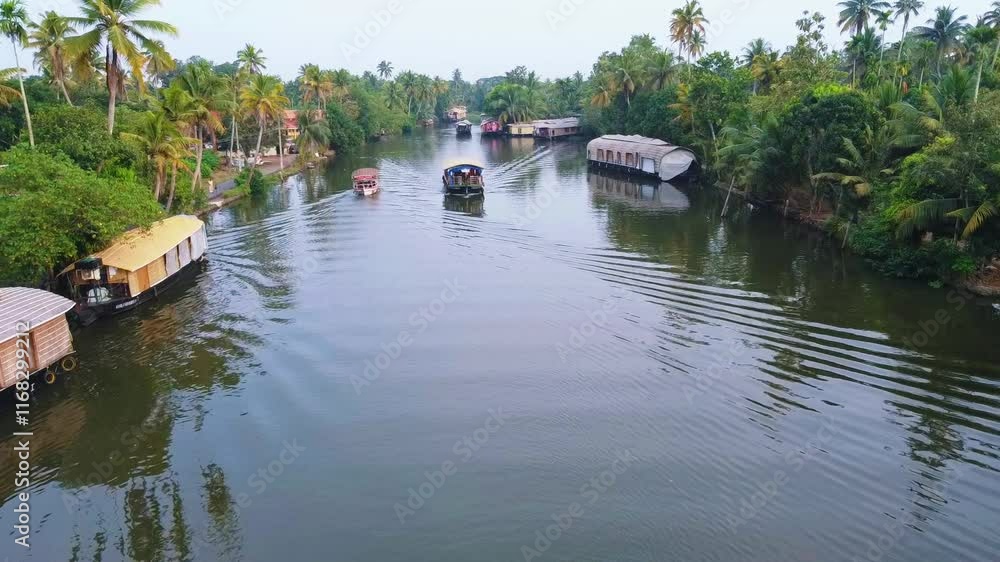 Kerala village tourism. Alappuzha Back water pollution , Aerial view of Kerala's backwaters with rows of houseboats lined up and a small boat sailing through the water nearby