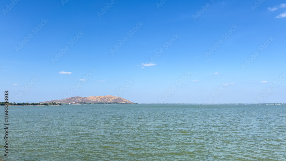 A photo of a reservoir with a beautiful atmosphere of water sources and blue sky on a clear day during the winter when leaves are falling. A photo of a reservoir with a beautiful atmosphere of water sources and blue sky on a clear day during the winter when leaves are falling.